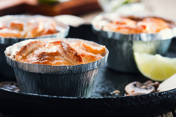 Steak and mushroom pot pies in  aluminum foil dishes on picnic table