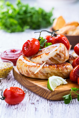 Grilled sausages and tomatoes in rustic style