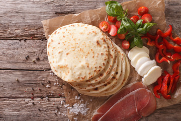 Italian piadina flatbread, ham, cheese and vegetables close-up. horizontal top view
