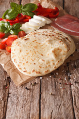 Italian freshly baked flat bread piadina close-up. vertical
