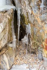 Grottoes and cracks in the rock with icicles.
