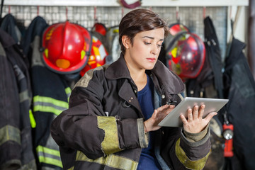 Fototapeta premium Firewoman Using Digital Tablet At Fire Station