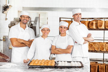 Confident Male And Female Baker's Standing At Table