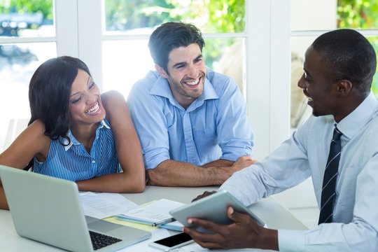 Couple and real estate agent discussing together