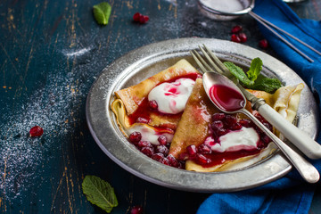 crepe pancakes with cream and pomegranate  sauce