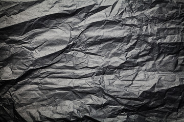 The dark texture of crumpled paper, black background