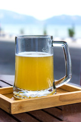 beer glass with blurred sea on background