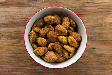 almonds in bowl on wooden background