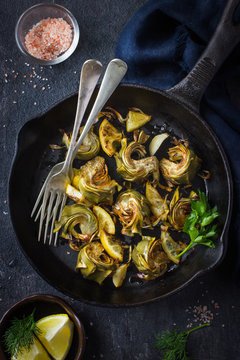 fried artichokes with garlic and lemon on pan
