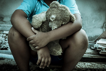 Vintage tone,Sad boy sitting alone with old teddy bear