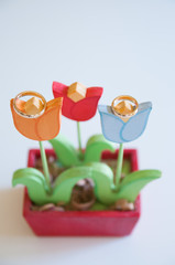 closeup of wedding rings in wooden flowers
