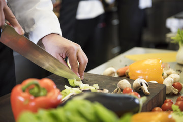 Professional cook chopping spring vegetables