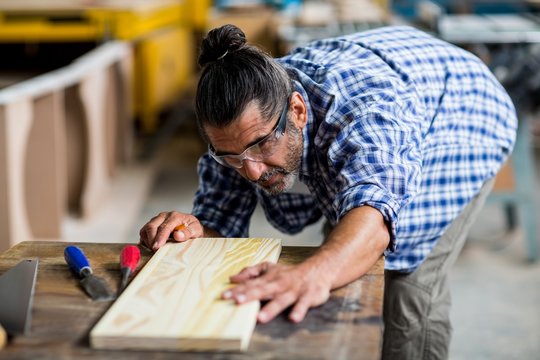 Carpenter measuring wooden plank