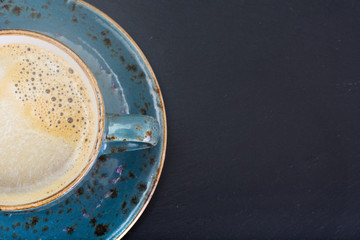 Coffee with milk, cappuccino in a blue retro cup.
