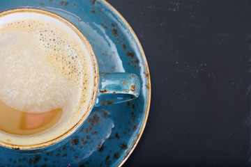 Coffee with milk, cappuccino in a blue retro cup.