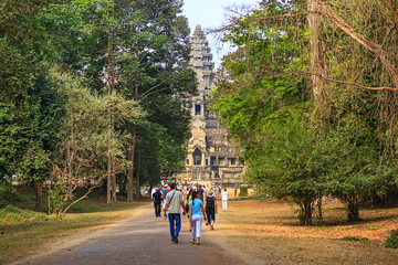 Fototapeta na wymiar Tourists on path go to Angkor Wat