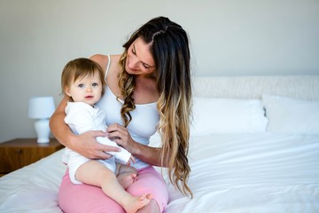 Fototapeta na wymiar brunette woman holding a baby on a bed