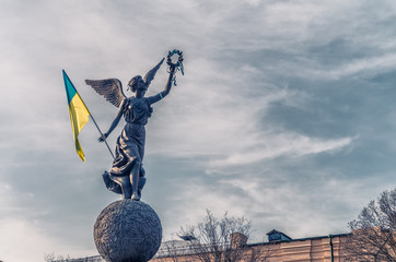 Monument in Kharkiv with ukrainian flag in sky