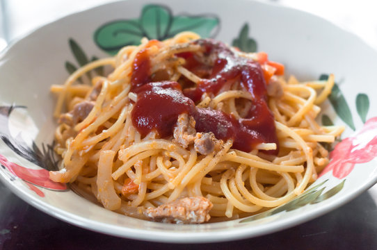 Fried spaghetti and pork with tomato source in plate