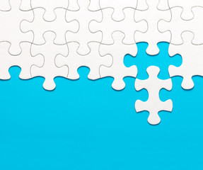 White jigsaw puzzle on blue background - obrazy, fototapety, plakaty