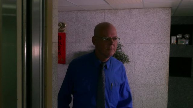 Businessman walks into elevator and pushes 1st floor button