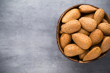 Group of almond nuts with leaves.Wooden background.