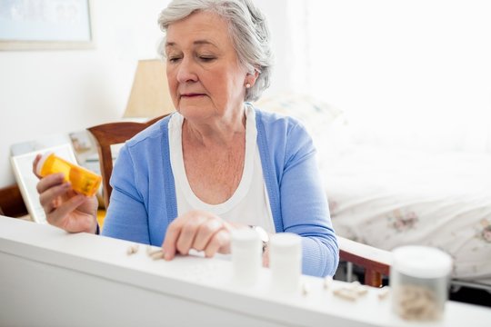 Senior woman taking her medicine at home