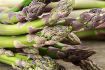 Bunch of fresh green purple asparagus tips macro closeup