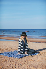girl reading a book sitting on the beach