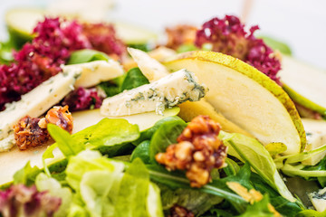 fresh lettuce salad with blue cheese, pear and caramelized walnuts, product photography for restaurant and healthy lifestyle