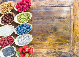 Superfood, detox, food.Berries, seeds, nuts, fruits top view on wood background text space.