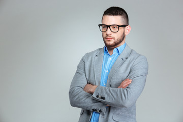 Pensive businessman standing with arms folded