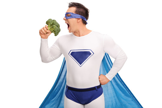 Young superhero eating broccoli