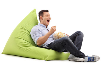 Guy eating popcorn and watching something