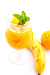 fresh orange smoothie with mint leaf in glass isolated on white background, orange, mango, carrot or banana drink, product photography for healthy lifestyle