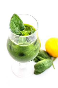 fresh green smoothie with spinach leaf and lemon in glass isolated on white background, spinach, cucumber, apple fruit drink, product photography for healthy lifestyle