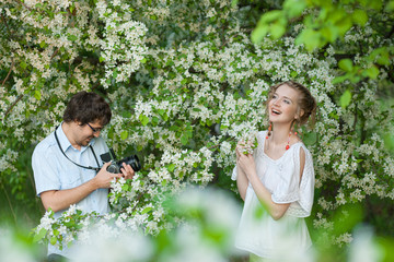 The man photographs the young girl in a garden