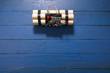 TNT bomb explosive with digital countdown timer clock over blue