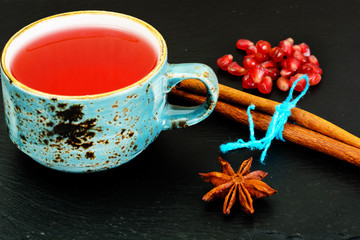 Obraz na płótnie Canvas Red Tea with beautiful cup, decorated with cinnamon and pomegran