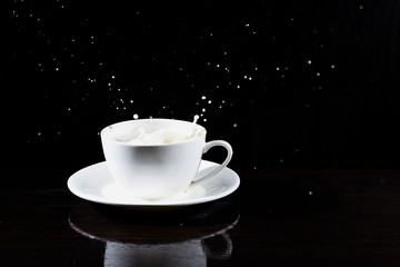 white cup of splashing milk