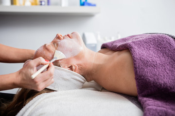 Woman Getting Facial Mask In Salon