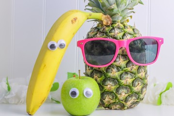 Pineapple wearing sunglasses and an apple and a banana with plastic eyes