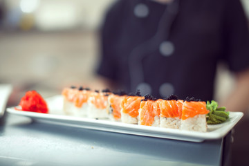 male cooks preparing sushi in the restaurant kitchen.