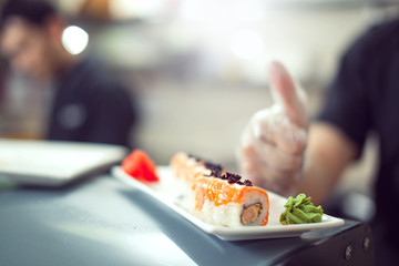 Naklejka premium male cooks preparing sushi in the restaurant kitchen.