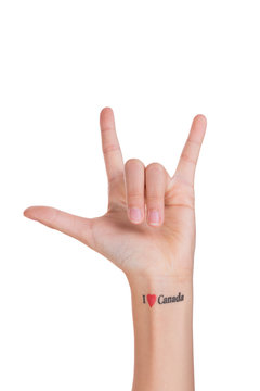Hand showing love sign with I love Canada tattoo
