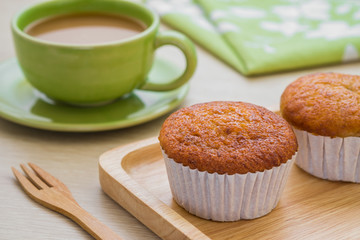 Banana cupcake on wooden plate and cup of coffee