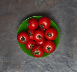 Fresh tomatoes in a green plate