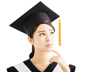 young female  graduation student looking up and thinking