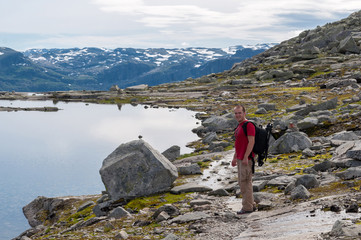 man walking on a mountain trail in Norway. Path to Trolltunga