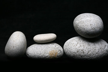 Fototapeta na wymiar Stack of stones - pebbles on black background